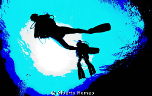 Divers in backlight by Alberto Romeo 